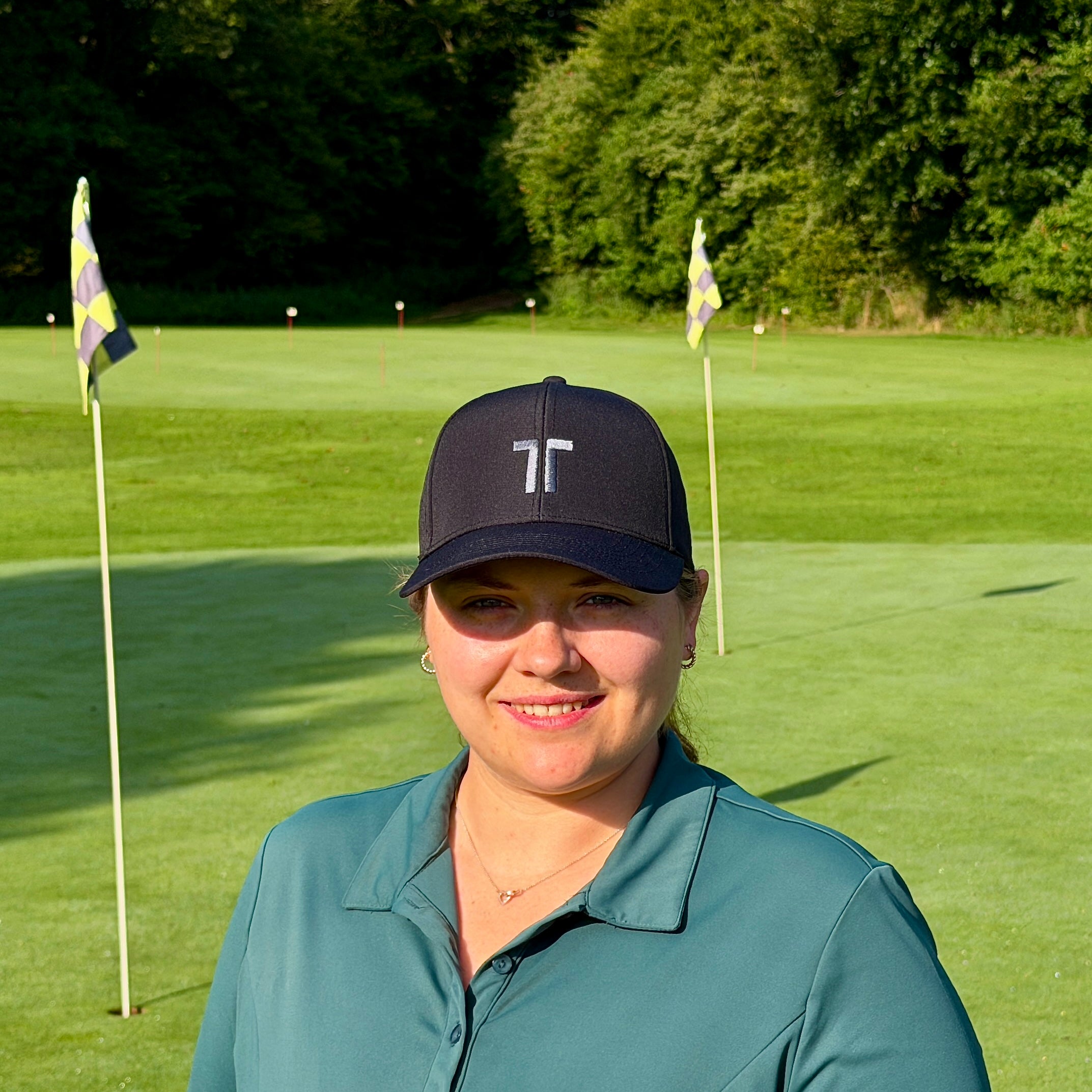 Person trägt THE CUTLINE Focus Cap in Schwarz auf dem Golfplatz